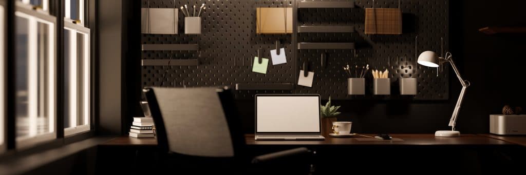 A dark home office with a laptop